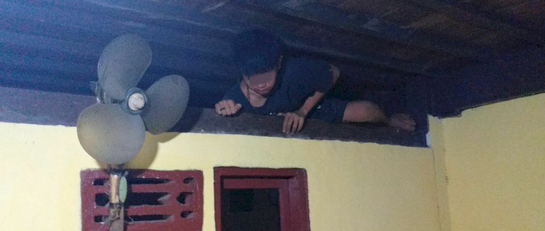 Pencuri difoto pemilik rumah saat berusaha kabur dengan memanjat dinding.