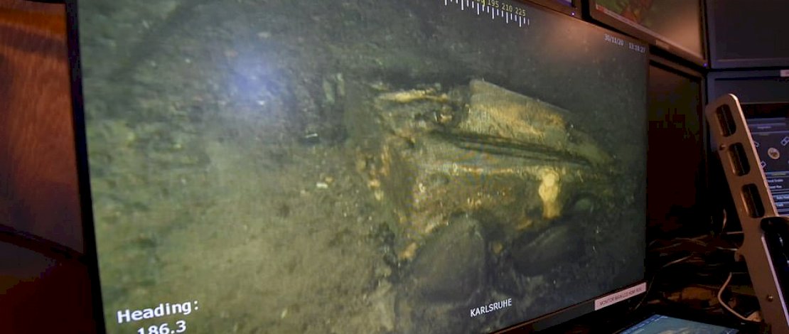 Sebuah layar menunjukkan bahwa survei sonar telah mengungkapkan peti dan benda lain yang tergeletak di sekitar kapal Nazi yang hancur. 

