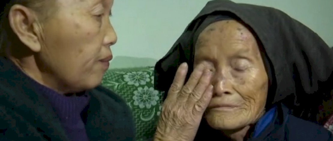 Dezliangz menyeka air mata dari wajah ibunya setelah bersatu kembali. (Foto: Huang Defeng)