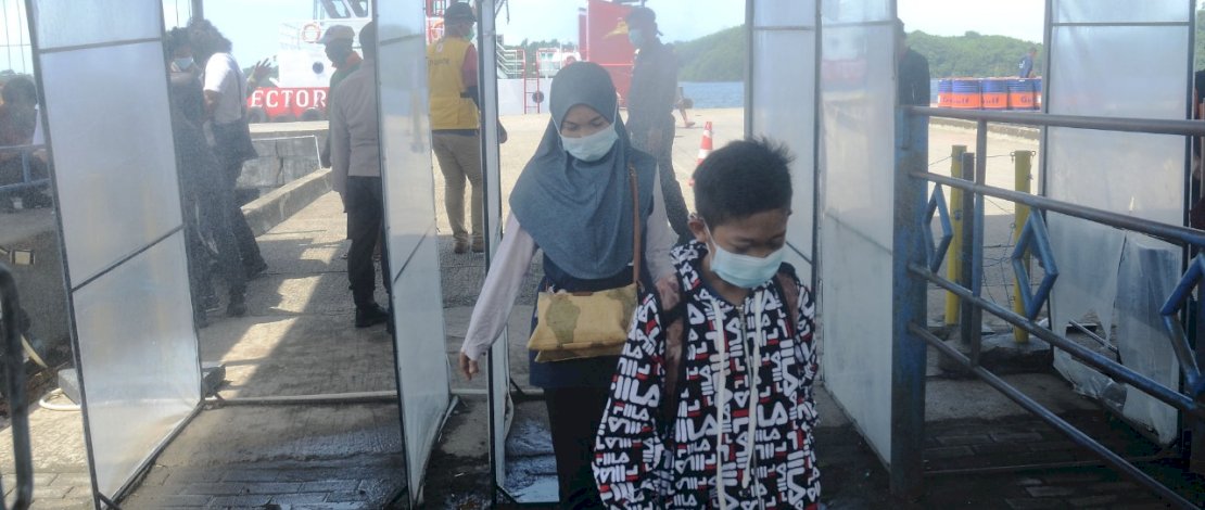 Petugas memeriksa suhu tubuh setiap penumpang angkutan laut yang tiba di Pelabuhan Nusantara Kota Parepare, Senin 21 Desember 2020. Pelabuhan Nusantara tetap menerapkan protokol kesehatan seperti pemeriksaan suhu tubu, bilik disinfektan guna mencegah penyebaran Covid-19. FOTOGRAFER/ZUL KIFLI