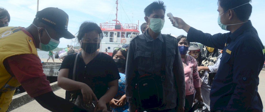 Petugas memeriksa suhu tubuh setiap penumpang angkutan laut yang tiba di Pelabuhan Nusantara Kota Parepare, Senin 21 Desember 2020. Pelabuhan Nusantara tetap menerapkan protokol kesehatan seperti pemeriksaan suhu tubu, bilik disinfektan guna mencegah penyebaran Covid-19. FOTOGRAFER/ZUL KIFLI