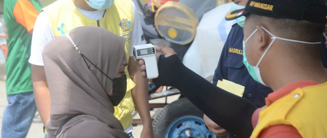 Petugas memeriksa suhu tubuh setiap penumpang angkutan laut yang tiba di Pelabuhan Nusantara Kota Parepare, Senin 21 Desember 2020. Pelabuhan Nusantara tetap menerapkan protokol kesehatan seperti pemeriksaan suhu tubu, bilik disinfektan guna mencegah penyebaran Covid-19. FOTOGRAFER/ZUL KIFLI