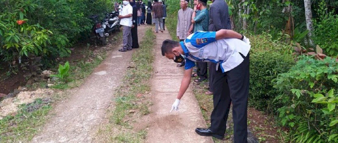 Seorang petugas menunjuk lokasi truk melindas tubuh Rista.