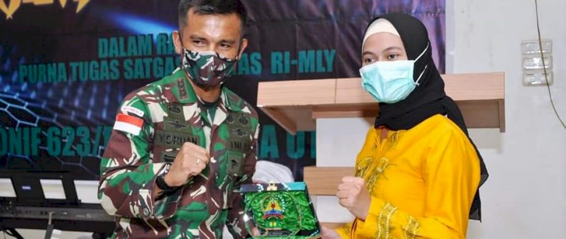 Bupati Nunukan Hj Asmin Laura Hafid (kanan), menyerahkan cenderamata keapda Komandan Yonif 623/BWU Letkol Inf Yordania.