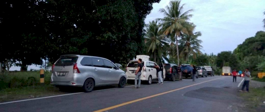 Material longsor menutup badan jalan yang menghubungkan Majene dan Mamuju. Akibatnya, antrean kendaraan mengular. (Foto: Zakir Sabara/Relawan Kemanusiaan FTI UMI)