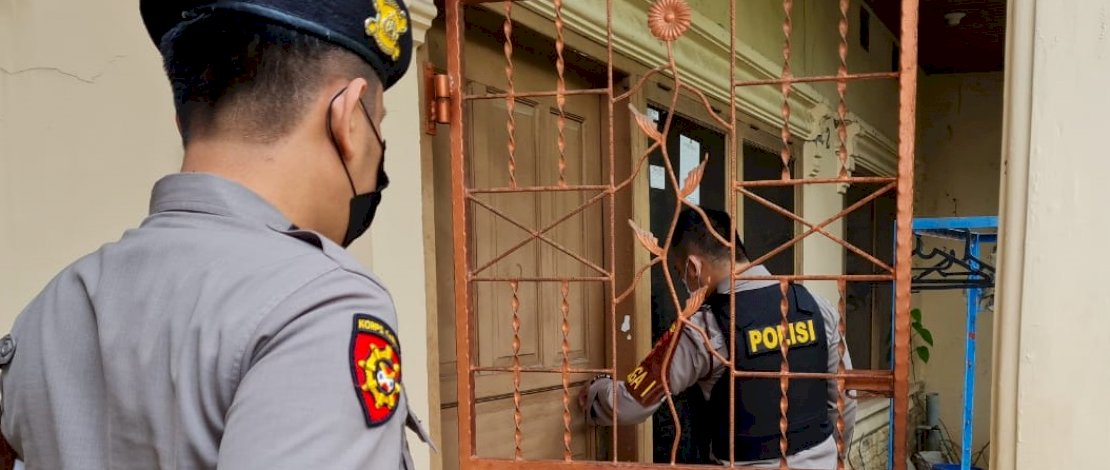 Polisi mencoba membuka pintu rumah korban, dan warga yang berkerumun di dekat lokasi penemuan mayat di Kompleks Lily, Panakkukang, Makassar.