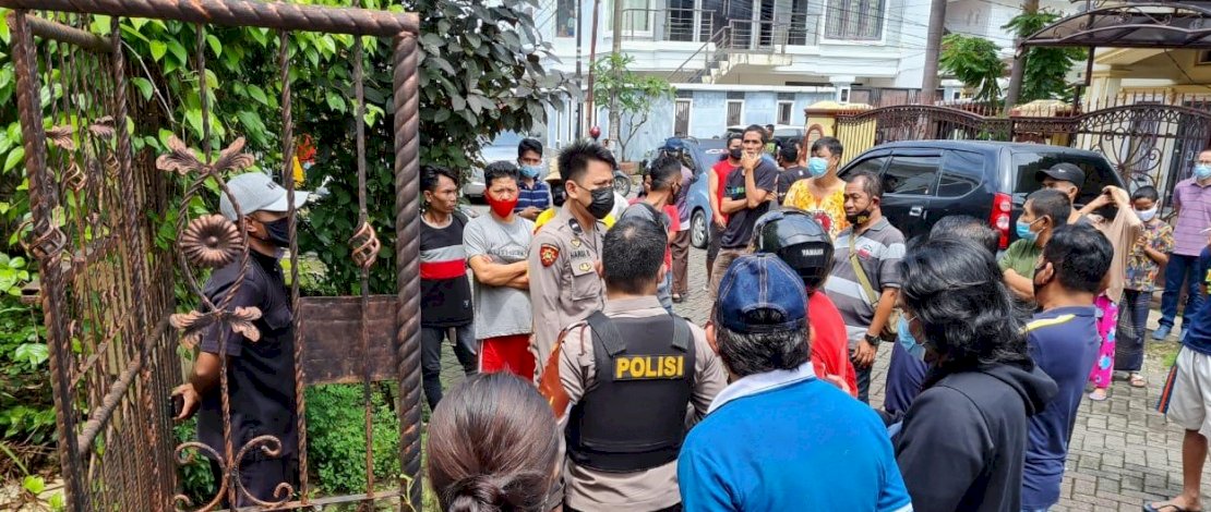Polisi mencoba membuka pintu rumah korban, dan warga yang berkerumun di dekat lokasi penemuan mayat di Kompleks Lily, Panakkukang, Makassar.