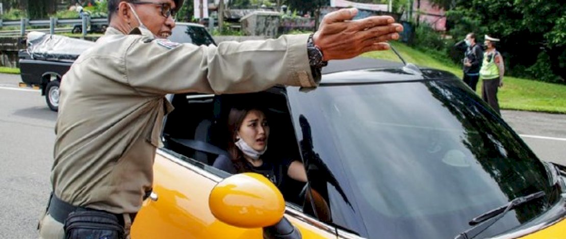 Anggota Satpol PP Kota Bogor, mengarahkan Ayu Ting Ting untuk memutar setelah terjaring aturan ganjil genap.