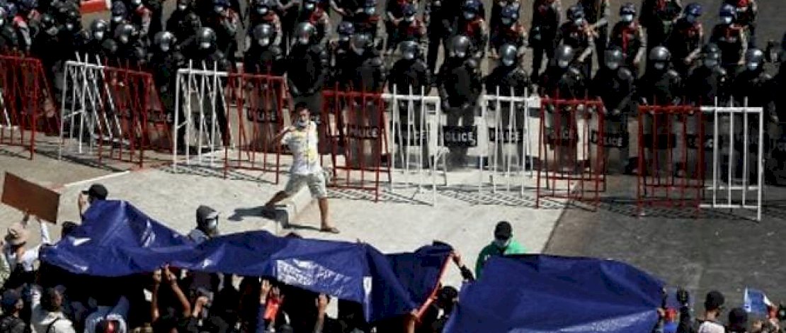 Pengunjuk rasa berhadapan dengan polisi anti huru hara selama demonstrasi menentang kudeta militer di Yangon pada 9 Februari 2021. (Foto: Sai Aung Main / AFP)