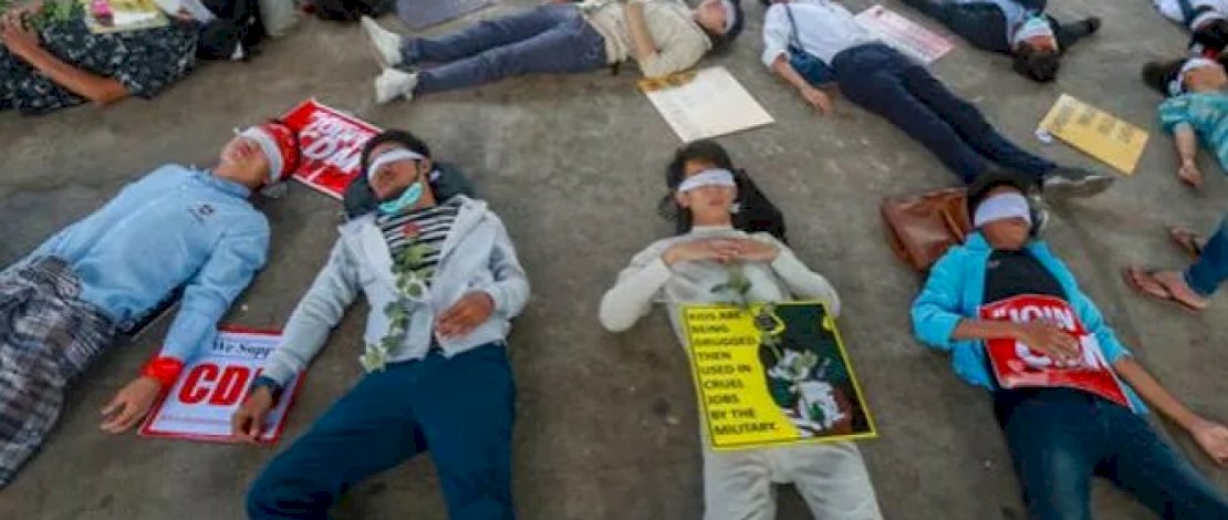 Demonstran, dengan mata tertutup, berbaring di jalan untuk memprotes kudeta militer di Yangon, Myanmar, pada 16 Februari 2021. (Foto: AP)