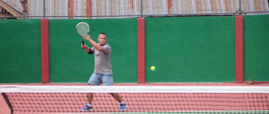Kompol Nur Ichsan tampak lincah memukul bola dalam permainan tenis lapangan, Sabtu (6/3/2021)