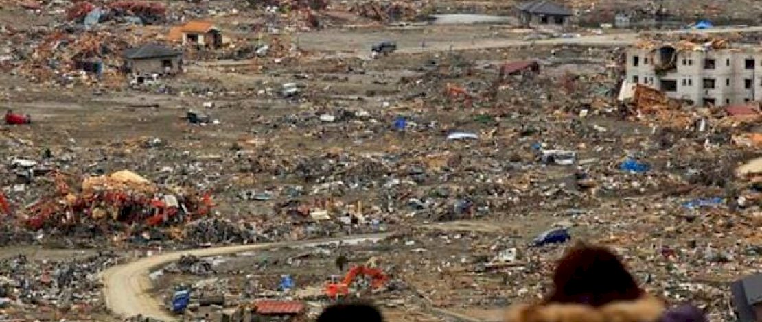 File foto 21 Maret 2011 - Warga melihat kerusakan akibat tsunami dari sebuah bukit tempat berlindung yang didirikan di sebuah sekolah di Minamisanriku, Jepang bagian utara. (File foto: Matt Dunham)