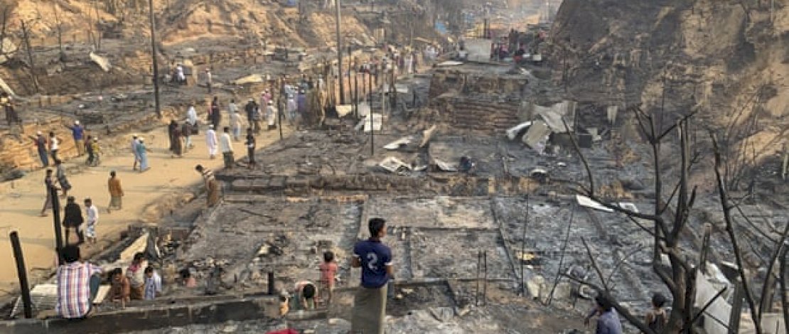 Pengungsi Rohingya melihat sisa-sisa kebakaran hari Senin di kamp di Balukhali, Bangladesh selatan. (Foto: Shafiqur Rahman / AP)
