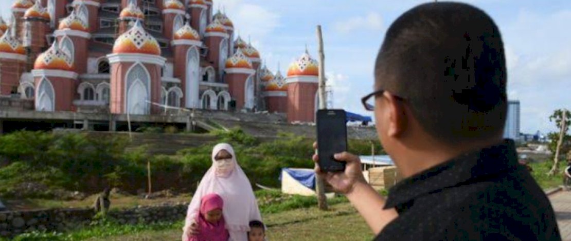 IST
MASJID 99 KUBAH. Pengunjung CPI berfoto dengan latar Masjid 99 Kubah. Warga berharap masjid ini bisa segera difungsikan.