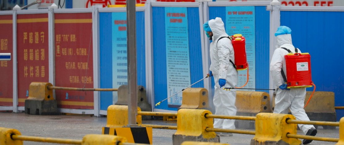 Pekerja menyemprot diinfectant di pasar Baishazhou selama kunjungan tim WHO di Wuhan, China. (Reuters / Thomas Peter)
