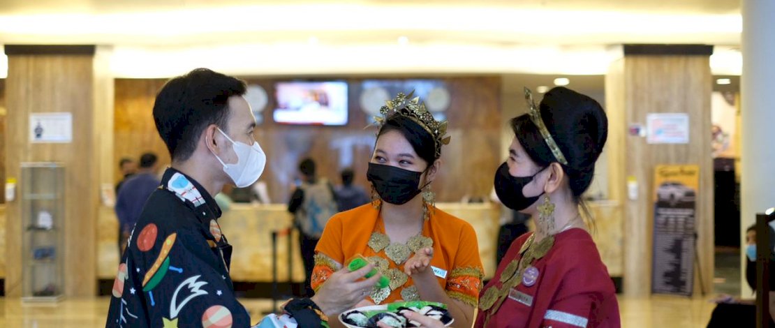 Karyawati Claro melayani tamu dengan memakai baju adat.