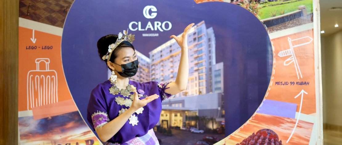 Karyawati Claro melayani tamu dengan memakai baju adat.