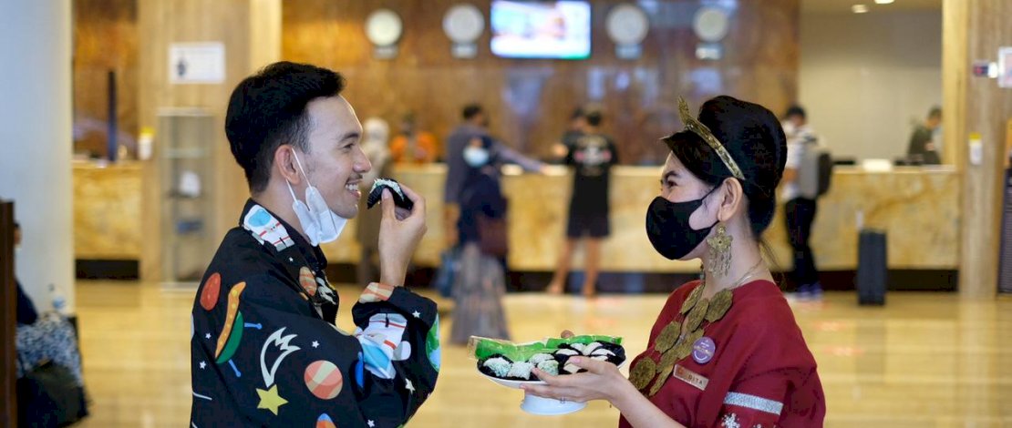 Karyawati Claro melayani tamu dengan memakai baju adat.