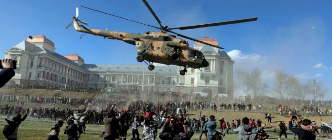 Sebuah helikopter militer terbang di atas orang-orang selama Pameran Pasukan Keamanan Afghanistan, di Istana Darul Aman di Kabul. (AP)