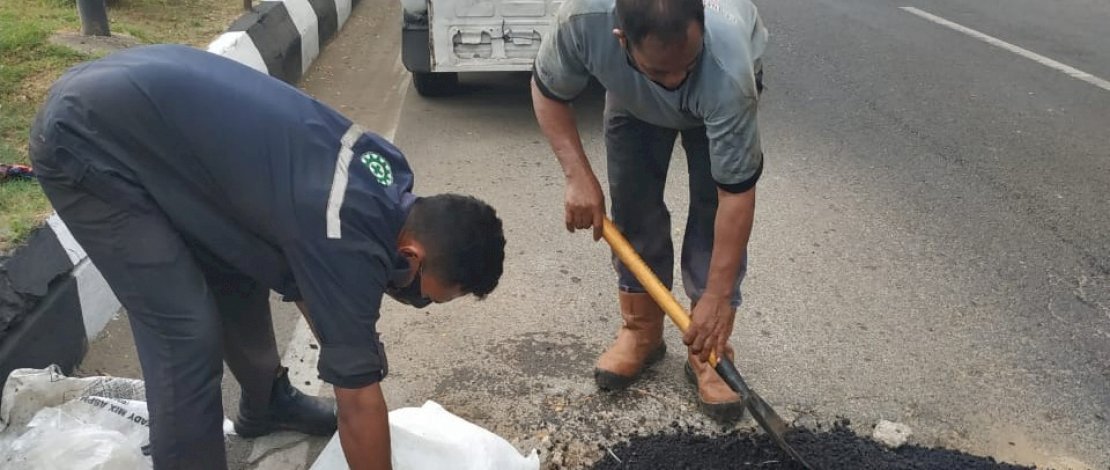 Komunitas MCC berinisiatif menambal jalan berlubang.