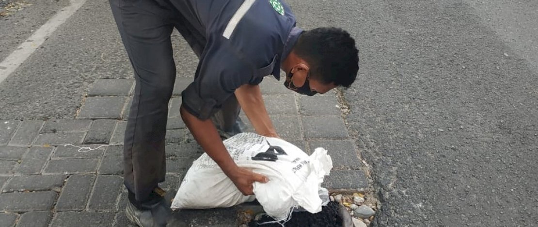 Komunitas MCC berinisiatif menambal jalan berlubang.