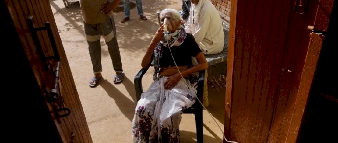 Seorang wanita dengan kesulitan bernapas menerima perawatan di sebuah klinik yang didirikan oleh seorang penduduk desa setempat di desa Parsaul di Greater Noida, di negara bagian utara Uttar Pradesh, India [Adnan Abidi / Reuters]