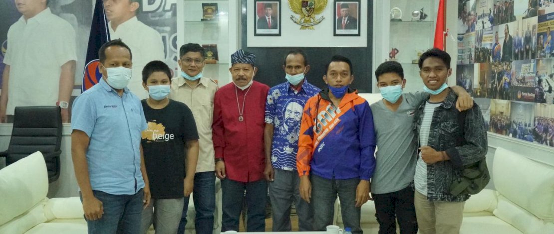 Sekretaris NasDem Sulsel, Syaharuddin Alrif memakaikan batik kepada Samidin, pria Buton yang nekat mengarungi laut pulang ke Buton dengan mendayung perahu karena tak punya ongkos. 