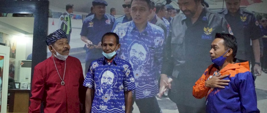 Sekretaris NasDem Sulsel, Syaharuddin Alrif memakaikan batik kepada Samidin, pria Buton yang nekat mengarungi laut pulang ke Buton dengan mendayung perahu karena tak punya ongkos. 