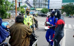 Polisi 'Super Hero' Bagikan Masker Tekan COVID-19, Hibur Pengendara Makassar