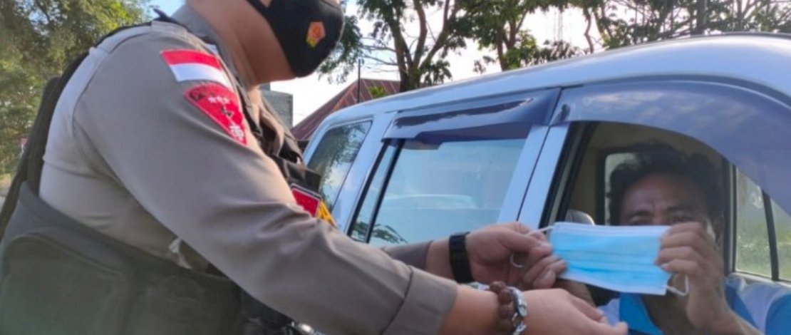 Personel Satuan Samapta Polres Luwu membagi-bagikan masker.
