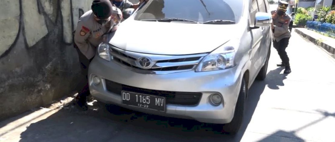 Kapolres Pelabuhana dan anggotanya mengevakuasi sebuah mobil yang terperosok ke dalam parit.