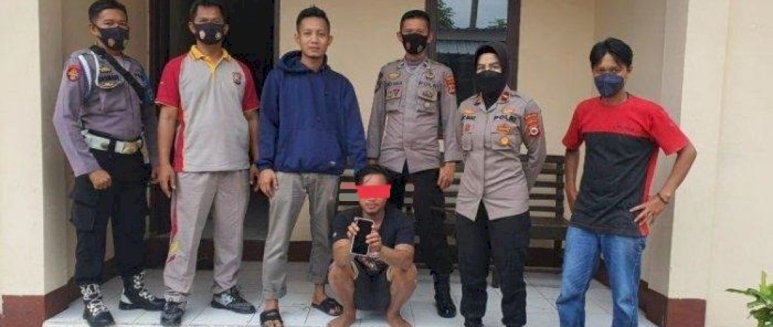 Jeki (jongkok) saat diamankan usai membeli ponsel curian dari orang tak dikenal.