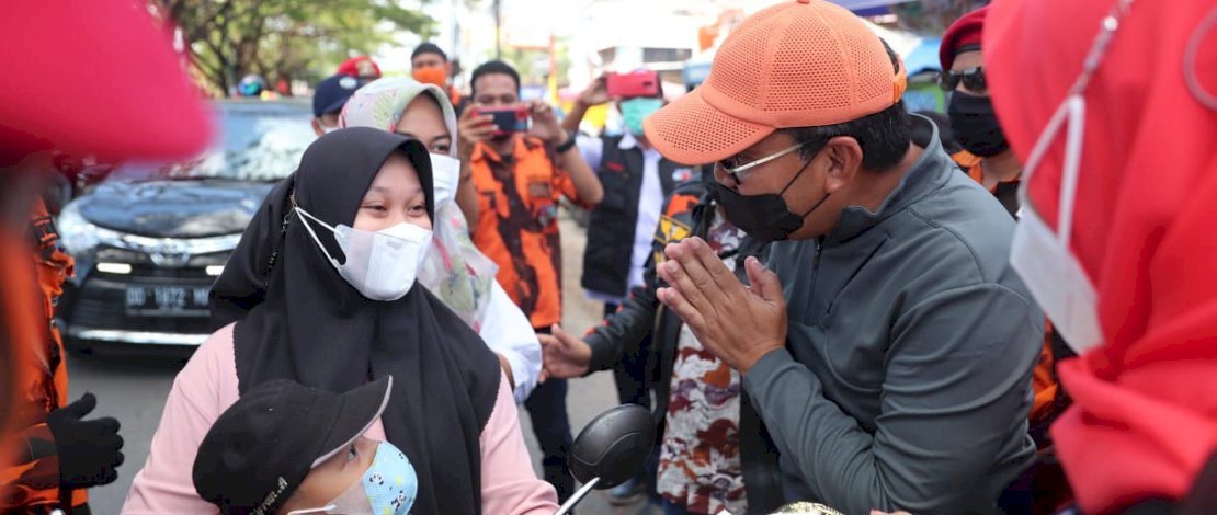 Wali Kota Makassar, Moh. Ramdhan ‘Danny’ Pomanto membagikan masker kepada paengendara yang lewat di depan pasar Antang, Kecamatan Manggala, Minggu (15/8/21). 