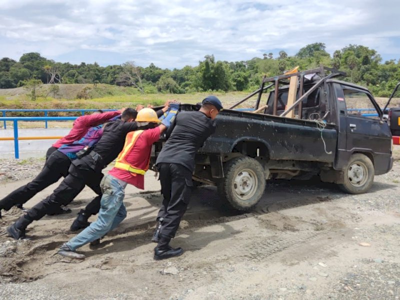 Danyon Brimob Bone Bantu Evakuasi Mobil Pickup Terjebak Lumpur