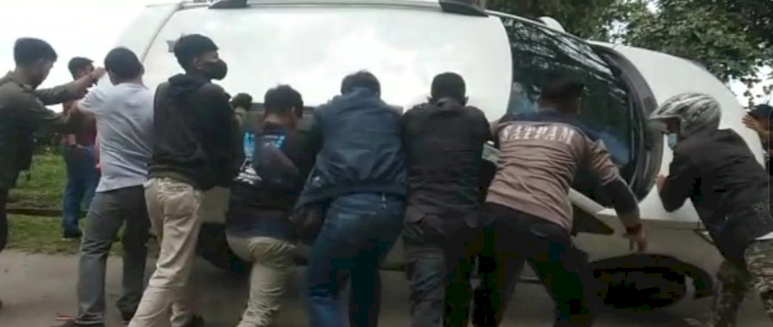 Warga membantu menegakkan kembali sebuah mobil yang terbalik di depan Kantor Bupati Luwu Utara.