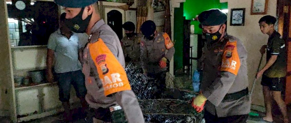 Anggota Brimob Bone membersihkan puing-puing kebakaran. FOTO/IST
