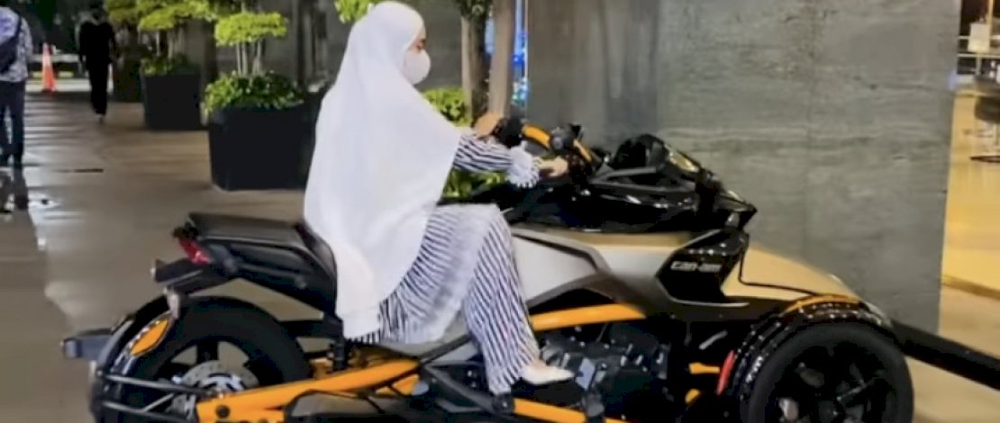 Potret April Jasmine menaiki Moge yang di parkir di halaman Mal. 