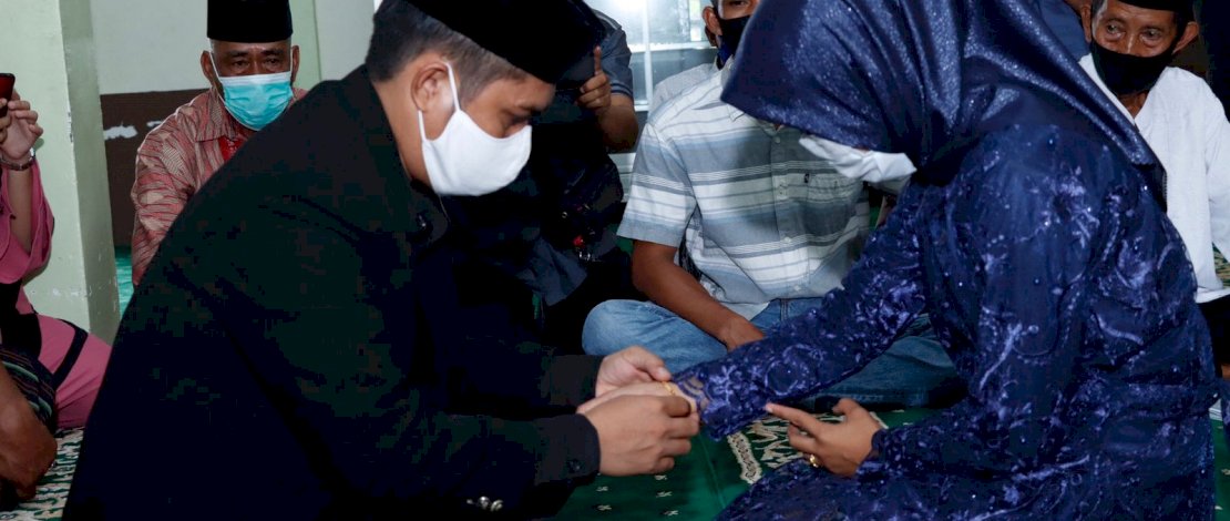 Lelaki AS terlihat memasangkan sebuah gelang kepada istrinya, NA usai ijab kabul di Masjid Polres Bulukumba, Rabu (1/12/2021).