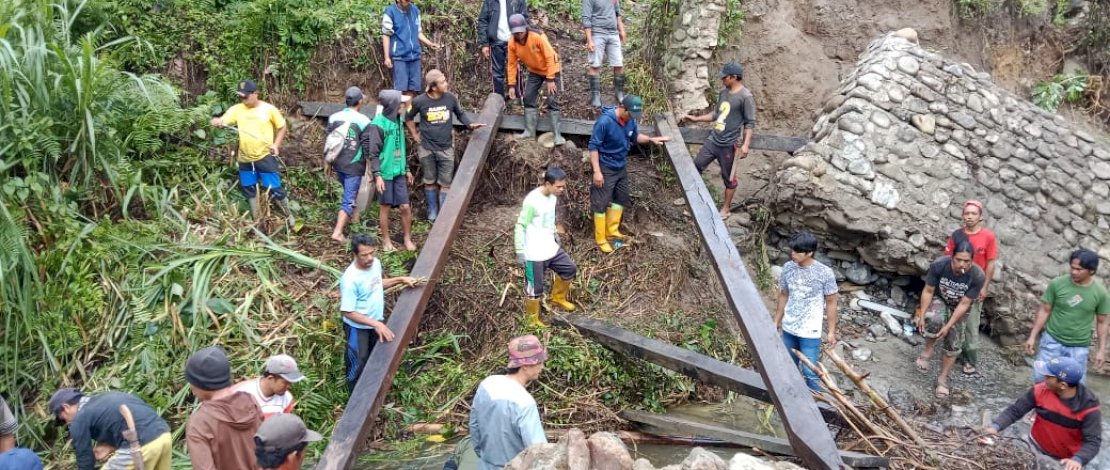 Warga bersama pemerintah setempat bergotong royong membangun jembatan darurat di Kecamatan Rampi, Senin, 6 Desember 2021.