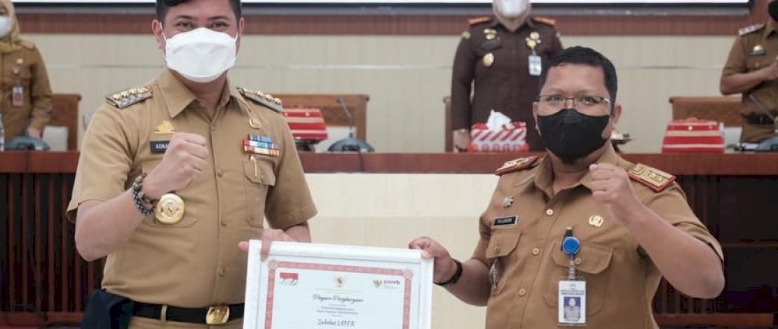Kepala Bagian Organisasi Setkab Gowa, Sujjadan menyerahkan penghargaan Top 99 Inovasi Pelayanan Publik 2021 dari  Kementrian Pendayagunaan Aparatur Negara dan Reformasi Birokrasi (Kemenpan RB) kepada Bupati Gowa, Adnan Purictha Ichsan YL di Baruga Karaeng Galesong, Kantor Bupati Gowa, Senin (27/12/2021).