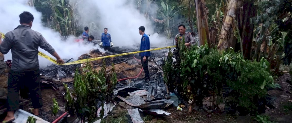 Anggota memasang garis polisi usai api berhasil dijinakkan oleh tim pemadam kebakaran.