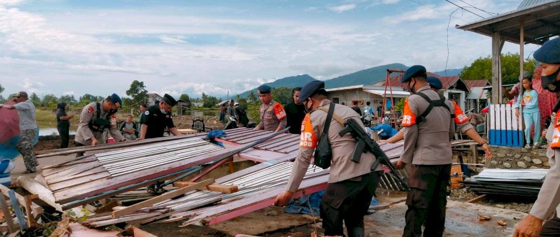 Puluhan anggota Polri dari Polres Luwu beserta Sat Brimob Polda Sulsel terjun langsung membantu korban bencana angin puting beliung yang terjadi di Desa Raja dan Desa Lengkong Karang karangan Kecamatan Bua, Kabupaten Luwu, Senin (10/1/2021).