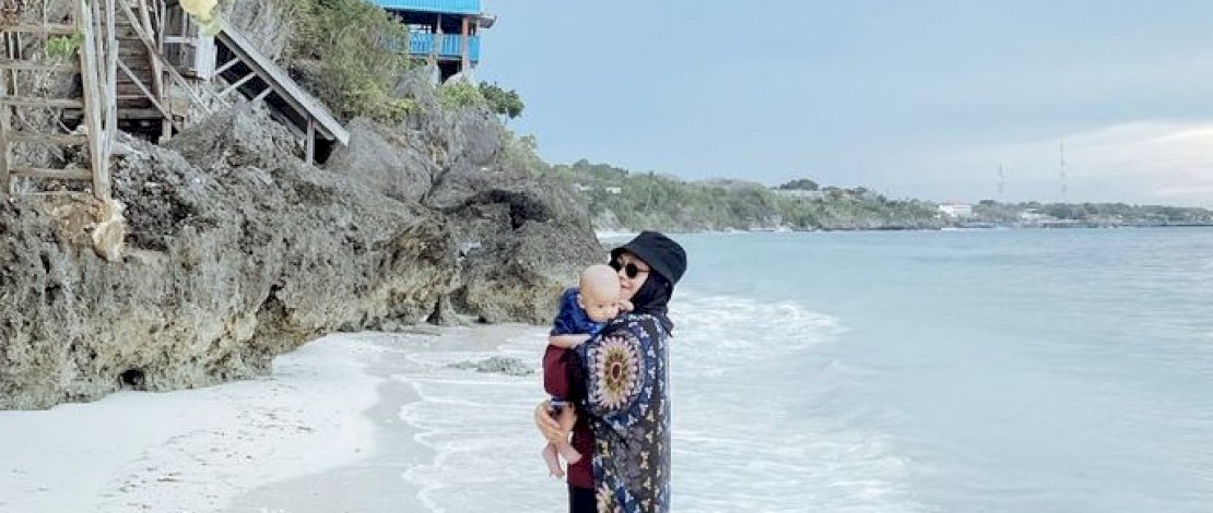 Potret Traveling di Pantai; salah satu pengunjung Pantai Bira Sulawesi Selatan bersama bayinya. 