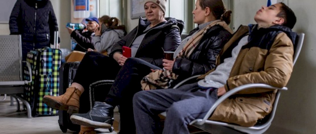 Sejumlah warga Ukraina beristirahat di gedung stasiun kereta api utama Przemysl di Polandia timur, Jumat (25/2/2022). Foto: Wojtek RADWANSKI/AFP