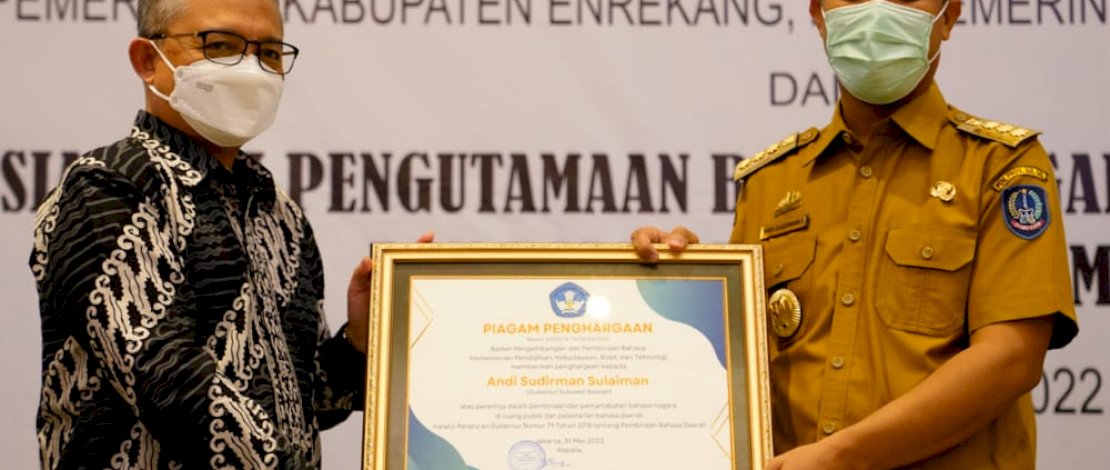 Kepala Badan Pengembangan dan Pembinaan Bahasa Kemendikbudristek, Prof E Aminuddin Aziz, menyerahkan piagam penghargaan kepada Gubernur Sulsel Andi Sudirman Sulaiman, pada acara Sosialisasi Pengutamaan Bahasa Negara di Ruang Publik dan Dalam Dokumen Lembaga, di Hotel Four Point by Sheraton Makassar, Selasa, 31 Mei 2022.