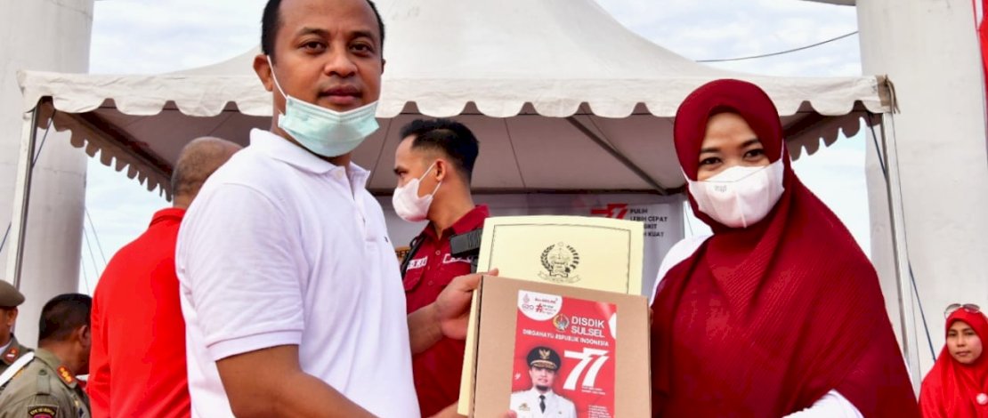 Gubernur Sulsel, Andi Sudirman Sulaiman, menyerahkan bantuan untuk guru berprestasi, pada acara jalan sehat Gerakan Sulsel Anti Mager (Malas Gerak) di CPI, Makassar, Jum'at, 12 Agustus 2022.