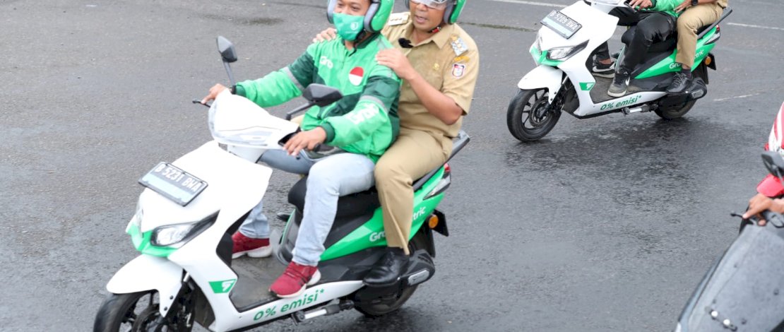 Naik Grab Bike , Danny Terobos Hujan Menuju Lokasi Kegiatan