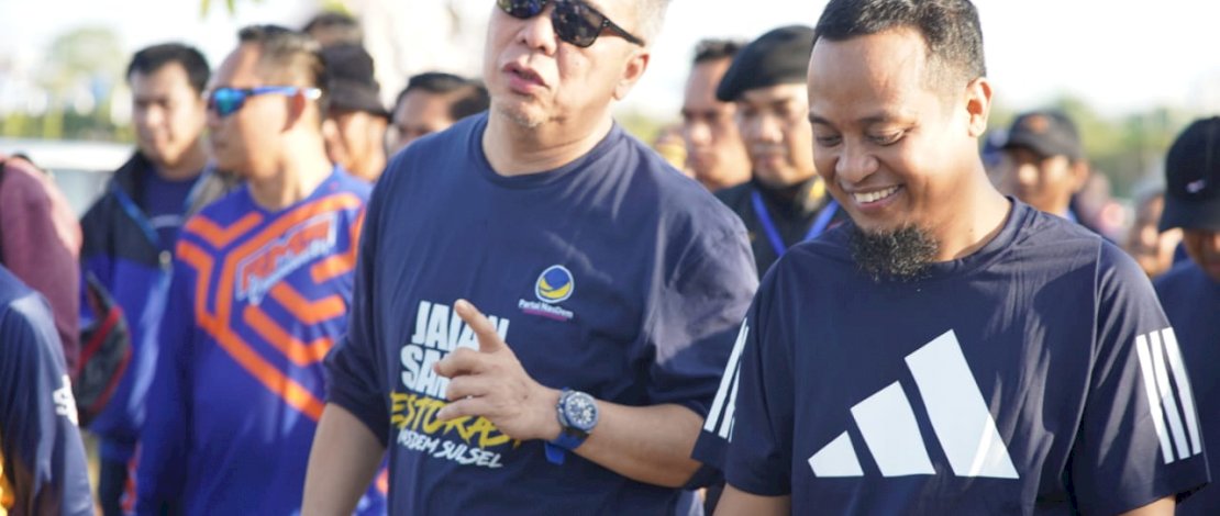 Gubernur Sulsel Andi Sudirman Sulaiman tampak akrab berbincang bersama Wakil Ketua Umum DPP Partai NasDem, Ahmad Ali, saat mengikuti Jalan Sehat Restorasi Partai Nasdem, di Center Point of Indonesia (CPI), Makassar, Minggu, 25 September 2022.