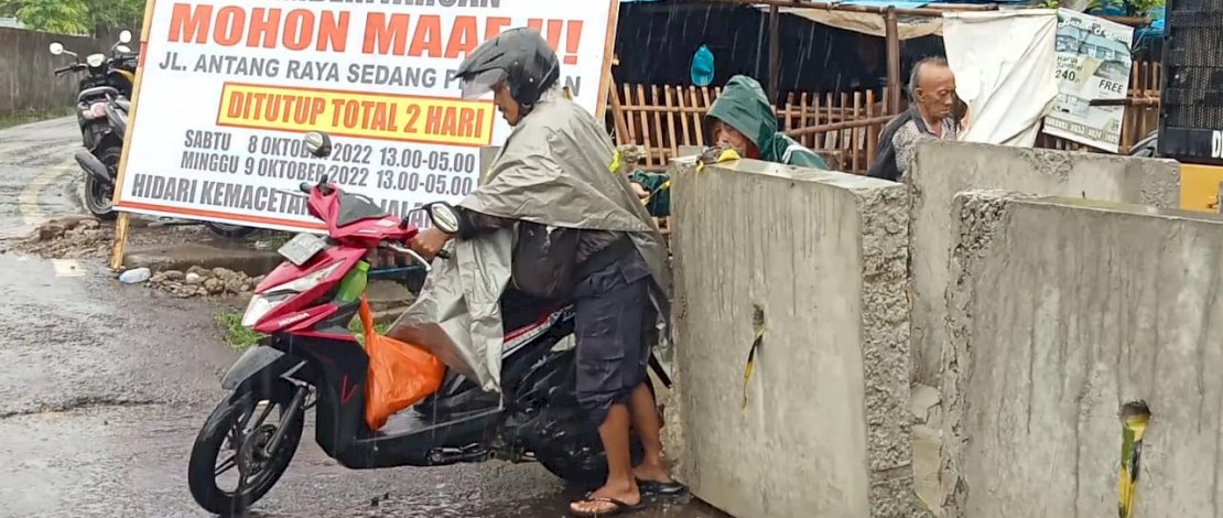 Salah seorang pengguna jalan tampak menerobos pembatas beton yang dipasang menutup Jalan Antang Raya, Sabtu (8/10/2022). Jalan ini ditutup total untuk sementara, dalam rangka perbaikan hingga Minggu (9/10/2022).