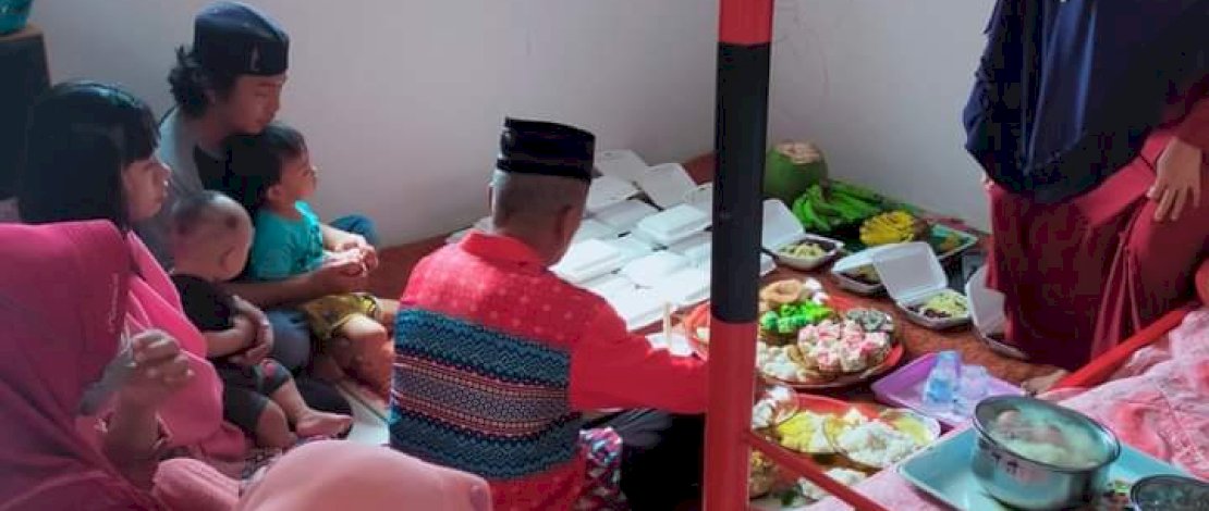Muhammad Siddiq dan Fitriani memangku anak mereka saat menjalankan tradisi syukuran masuk rumah baru di BTN Griya Hana Lestari Bantaeng. 